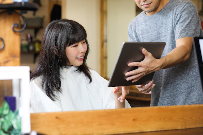 ヘアスタイルを美容師と相談している女性